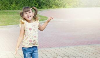 weinig gelukkig jumping meisje. gelukkig kind Aan de straat. buitenshuis spellen foto