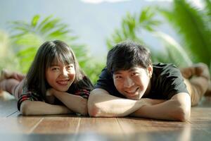 toothy glimlachen geluk gezicht van Aziatisch jonger paren aan het liegen Aan hout verdieping foto