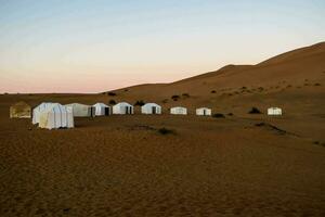 de tenten zijn in de woestijn met zand duinen foto