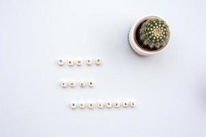 cactus op de witte tafel naast een inscriptie Grove uw bedrijf foto