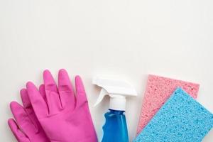 latex handschoenen, spray en keuken sponsachtige liyng op een witte achtergrond, kopieer ruimte foto