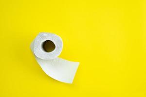 wit toiletpapier geïsoleerd op gele achtergrond. bovenaanzicht foto