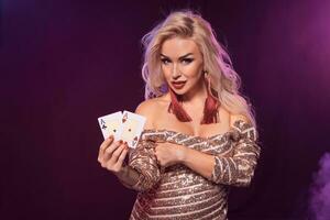 blond vrouw met een perfect kapsel en helder bedenken is poseren met spelen kaarten in haar handen. casino, poker. foto