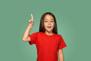 weinig meisje in rood t-shirt met vinger omhoog foto