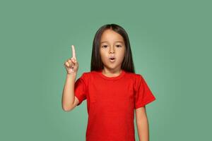 weinig meisje in rood t-shirt met vinger omhoog foto