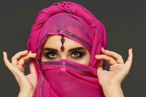 detailopname schot van een jong charmant vrouw vervelend de roze hijab versierd met pailletten en sieraden. Arabisch stijl. foto