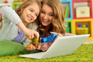 moeder en dochter samen met behulp van laptop foto