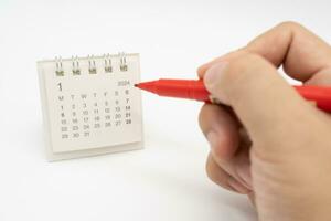 maand planning in de kalender. 2024 jan kalender. rood pen voor markering datum. afspraak kalender en pen. foto
