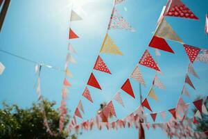 ai gegenereerd levendig rood en wit vlaggedoek feestelijk hangende met driehoekig vlaggen voor feesten. ai gegenereerd foto