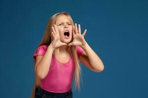 portret van emotioneel weinig meisje Aan blauw achtergrond foto