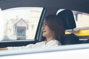 Dames zittend in de stoel en het rijden een auto naar Gaan werk, concentratie Aan het rijden voor veiligheid vervoer concept foto