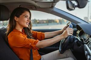 schattig jong dame gelukkig het rijden auto. beeld van mooi jong vrouw het rijden een auto en lachend. portret van gelukkig vrouw bestuurder stuurinrichting auto met veiligheid riem foto