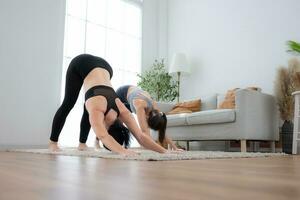 twee jong vrouw beoefenen yoga met instructeur in huis. individu yoga klasse beoefenen in huis foto