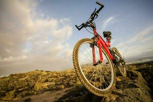 een rood fiets is zittend Aan top van een rots foto