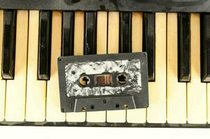 een oud cassette is zittend Aan top van een piano foto