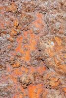 een roestig metaal oppervlakte met oranje verf foto