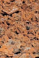 een dichtbij omhoog van een rots met oranje en zwart rotsen foto