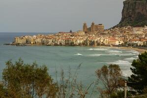 huizen langs de kustlijn en kathedraal in achtergrond, cefalu, Sicilië foto