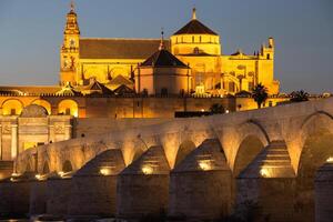 nacht visie van mezquita-kathedraal en puente romano - moskee-kathedraal en de Romeins brug in Cordoba, Andalusië, Spanje foto