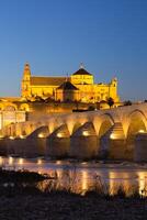 nacht visie van mezquita-kathedraal en puente romano - moskee-kathedraal en de Romeins brug in Cordoba, Andalusië, Spanje foto