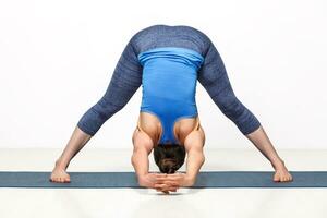 vrouw aan het doen yoga asana prasarita padottanasana foto