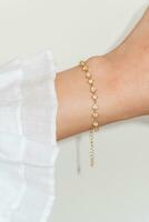 vrouw pols vervelend gouden zirkoon fonkeling armband reeks tegen een wit achtergrond. foto