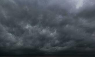 de donker lucht met zwaar wolken convergeren en een gewelddadig storm voordat de regen.slecht of humeurig weer lucht en omgeving. koolstof dioxide uitstoot, kas effect, globaal opwarming, klimaat verandering foto