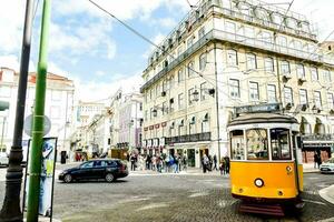 een geel tram Aan een stad straat foto