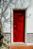 een rood deur en een boom in voorkant van het foto