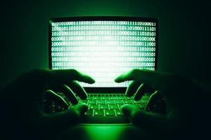 close-up van hacker gebruikt de laptopcomputer om virussen of malware te coderen voor het hacken van internetserver, cyberaanval, systeembreuk, internetcriminaliteitsconcept. foto