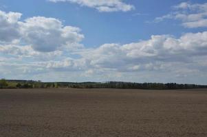 panorama van een lenteveld dat door een tractor wordt gewied foto