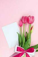 roze tulpen geschenk boeket met boog en papier. Internationale vrouwen en moeder dag, verjaardag, Valentijnsdag dag, vakantie. kopiëren ruimte foto