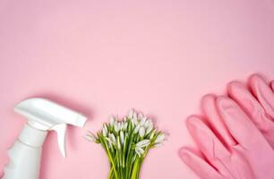 wasmiddel, voorjaar bloemen en rubber handschoenen Aan een roze achtergrond. voorjaar schoonmaak concept. plat leggen. kopiëren ruimte. top visie. foto