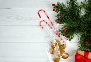 feestelijk Kerstmis samenstelling met peperkoek Mens en Spar takken Aan een wit houten achtergrond. kopiëren ruimte. top visie. plat leggen. foto