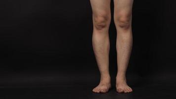 Aziatische mannelijke benen en blootsvoets is geïsoleerd op zwarte achtergrond foto