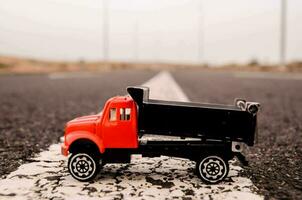 een speelgoed- rood dump vrachtauto Aan de weg foto