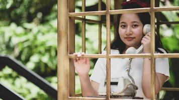 een lachend meisje poseren met een klassieke telefoon tijdens het reizen, ze glimlacht. foto