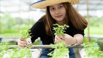 aziatische tienermeisjesboer die hydrocultuurgroenten toont in kas, slimme boerderij. foto