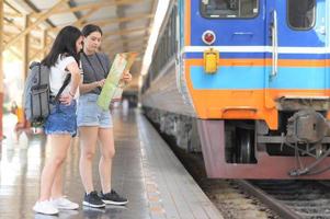 twee tienermeisjes kijken naar een kaart om met de trein te reizen. foto