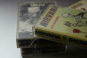 Bangkok, Thailand - februari ,09 2022 90's cassette banden van nirvana albums incesticide, laat maar, bleekmiddel, van de modderig banken van de wenskah, losgekoppeld in nieuw york Aan een grijs vloer. foto