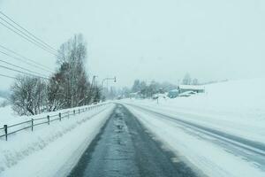 mooi sneeuw weg Woud visie gedurende auto het rijden in winter seizoen. winter reis, weg reis, avontuur, verkennen en vakantie concepten foto