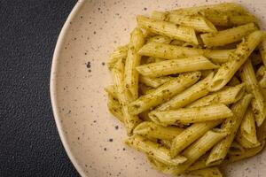 heerlijk vers pasta penne met groen pesto saus met basilicum, zout en specerijen foto