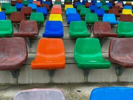 rijen van plastic stoelen van verschillend kleuren foto