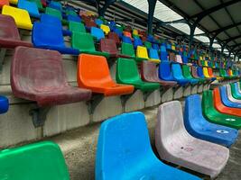 kant visie van rijen van plastic stoelen van verschillend kleuren vormen tribunes foto