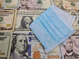 wegwerp gezichtsmasker op de achtergrond met Amerikaanse dollarbiljetten foto