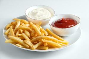 krokante frietjes in een bord op een witte achtergrond. warm Amerikaans fastfood. foto