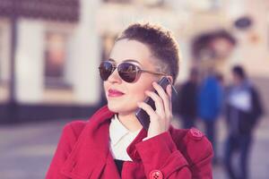 vrolijk meisje spreekt door telefoon in de middag foto