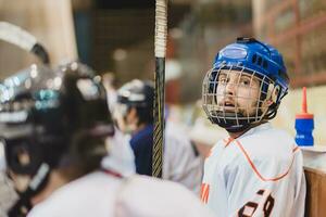 hockey spelers zitten Aan de bank gedurende de bij elkaar passen foto