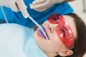 dokter orthodontist presteert een procedure voor schoonmaak tanden foto