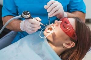 dokter orthodontist presteert een procedure voor schoonmaak tanden foto